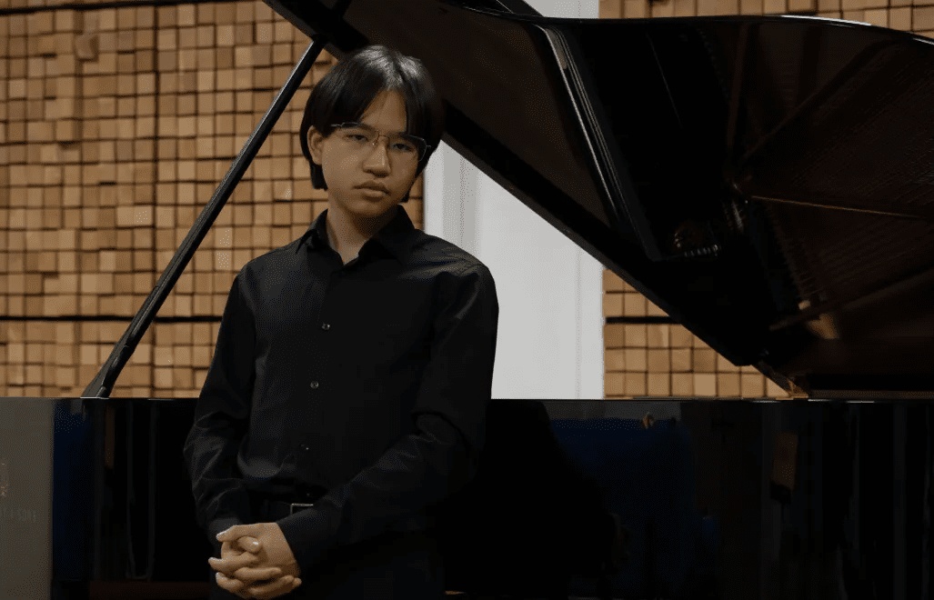 Vincent Ong posing by a grand piano