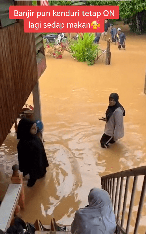 Wedding guests walk through floodwater in Kedah