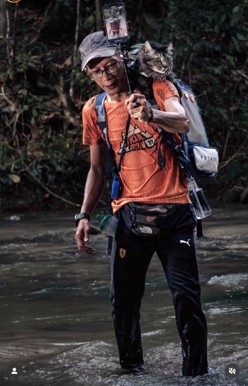 Azhan and his cat Jibek crossing a river together 