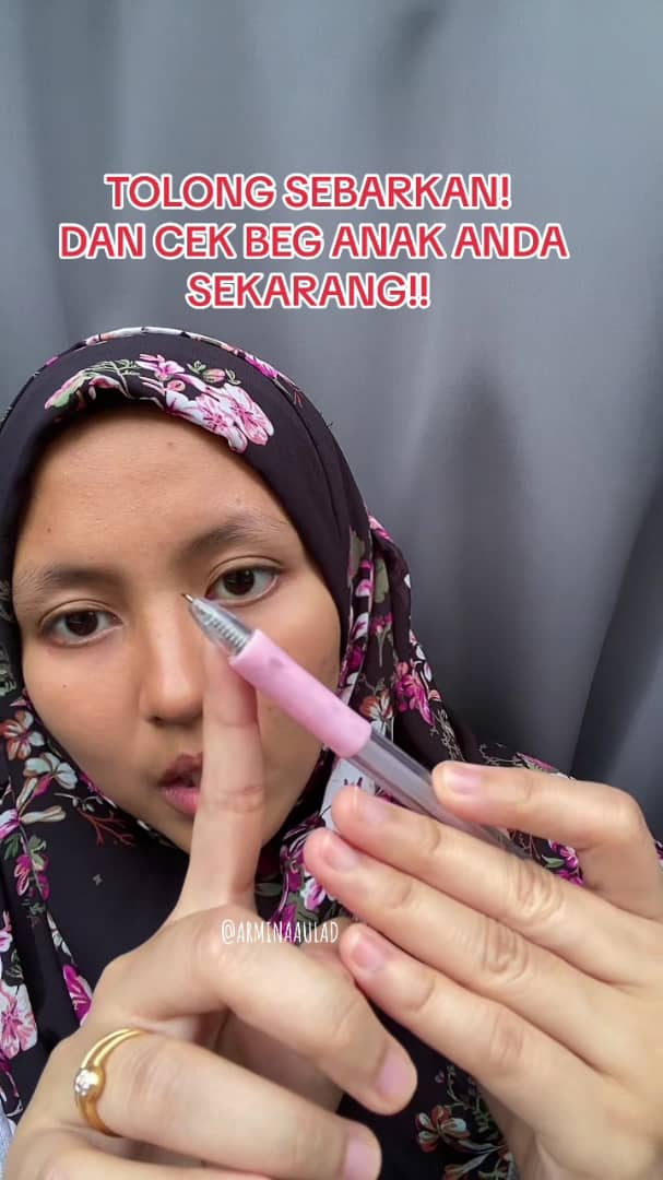 Msian teacher showing the pen cutter brough by one a student. 