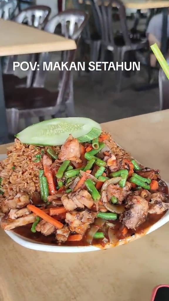 A M'sian shows the portion of fried rice that his friend received after ordering at a stall. 