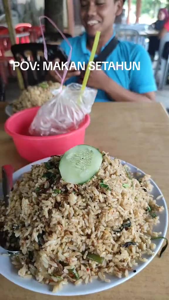 A M'sian shows the portion of fried rice that he received after ordering at a stall. 