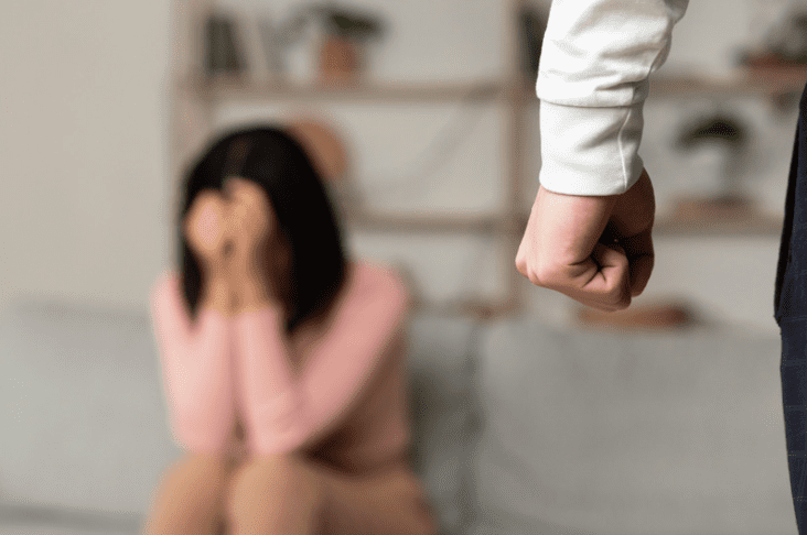 Woman hiding in fear from angry husband