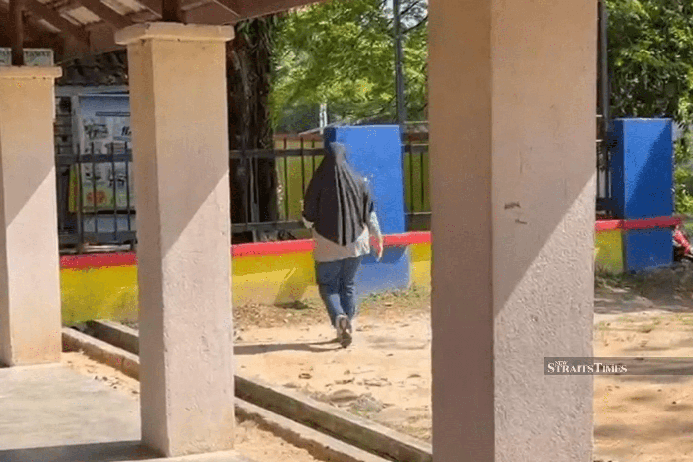 Woman putting flowers at Bandar Utama school