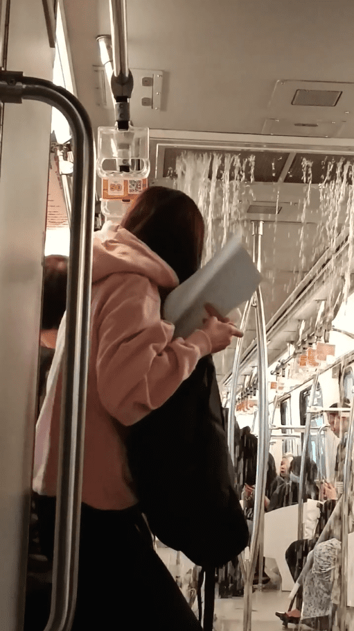 Woman running away from the pouring water in LRT
