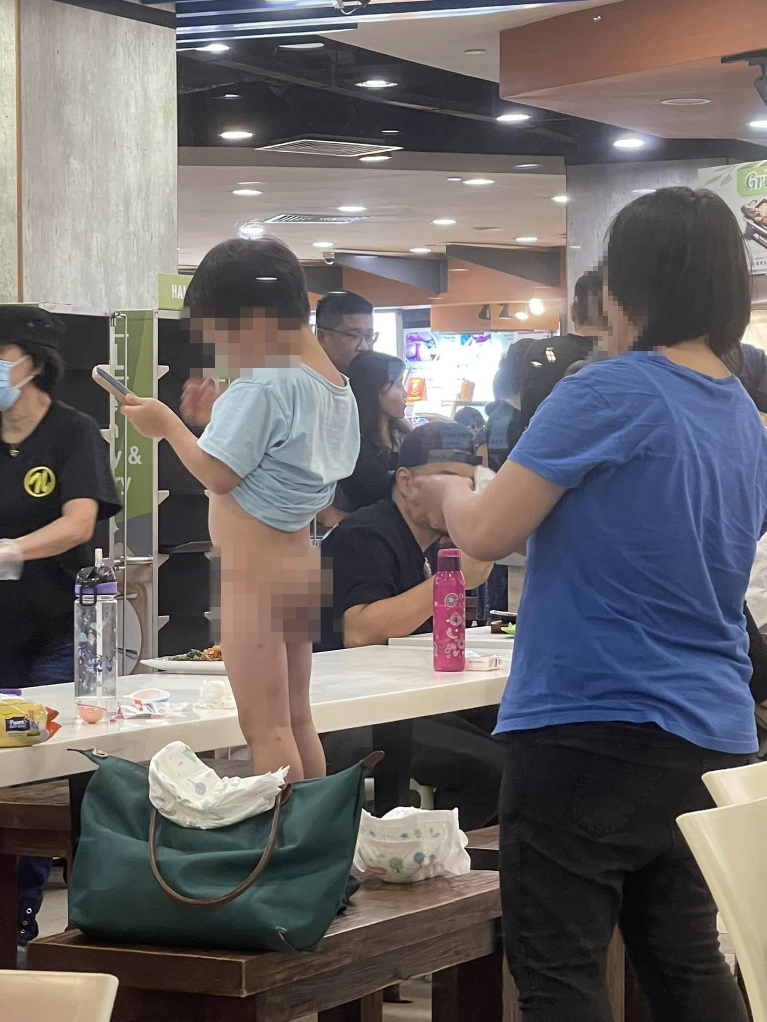 Woman using wet wipes to clean son's rear