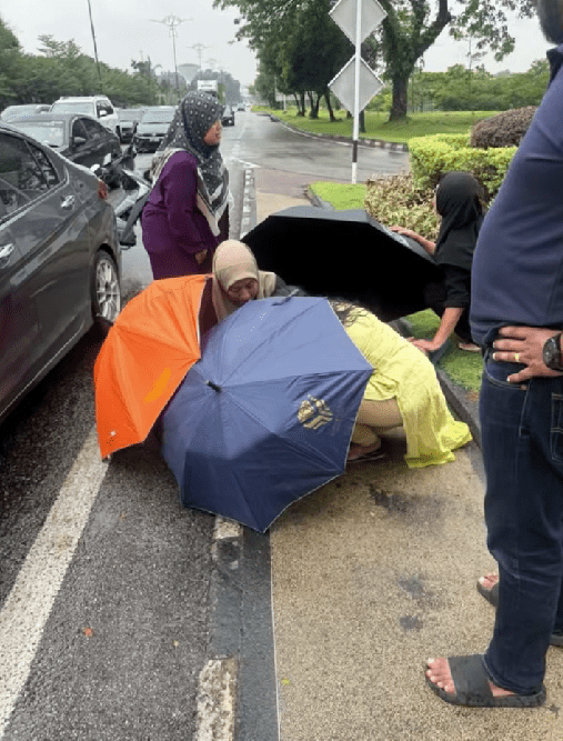 women helping a mother to deliver a baby on the road